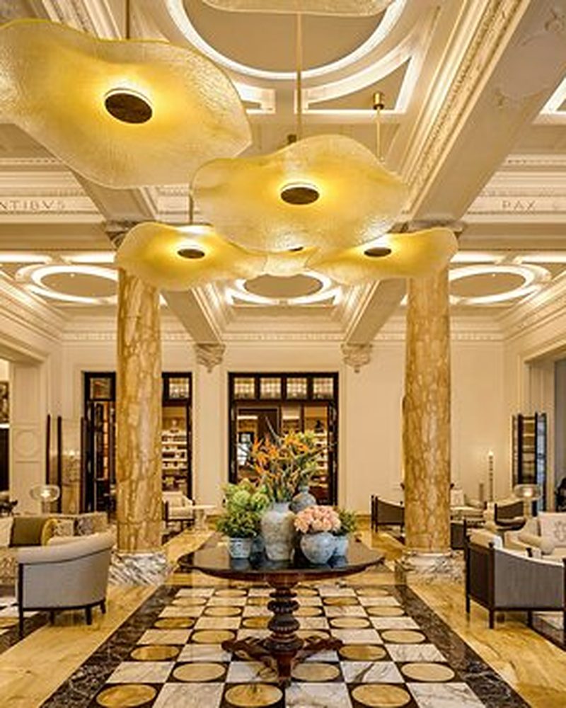 Lobby de hotel de luxo com colunas de mármore e iluminação dourada