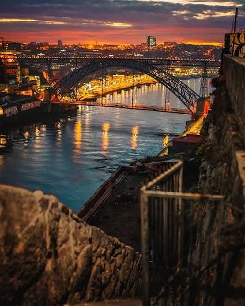 Rio Douro e Ponte Dom Luís I iluminados ao entardecer, no Porto