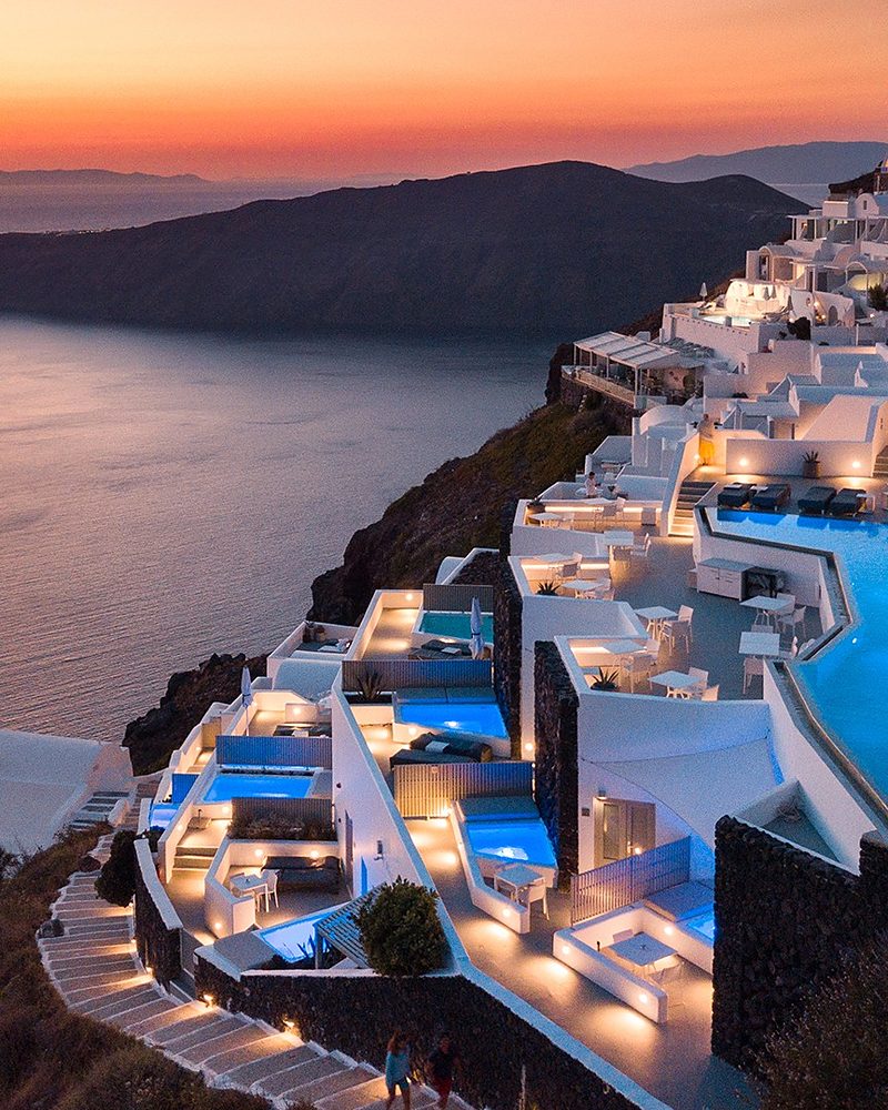 Terraço de hotel de luxo em Santorini com piscina ao entardecer