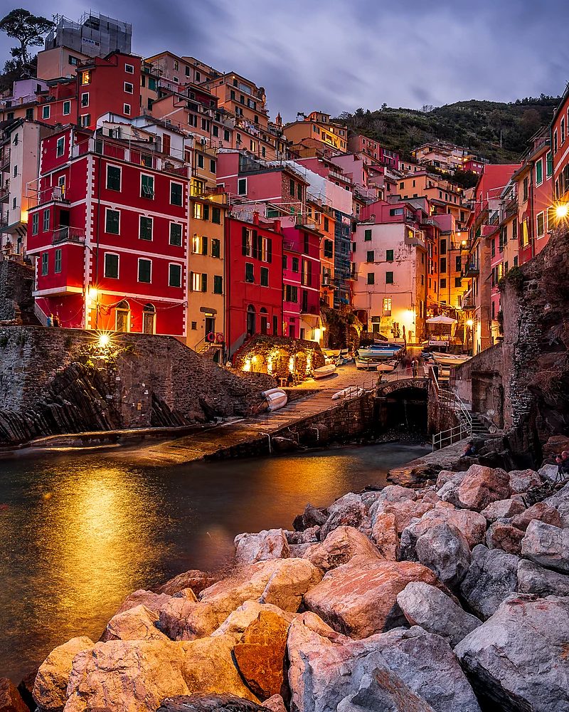 Vilarejo colorido de Cinque Terre sobre penhasco à beira-mar ao entardecer